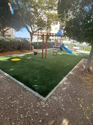 פינת משחקים בפארק ציבורי עם דשא סינטטי