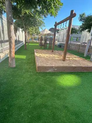 מתחם ציבורי עם דשא סינטטי ומתקני עץ