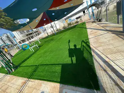 חצר בית ספר עם דשא סינטטי ומפרשי הצללה